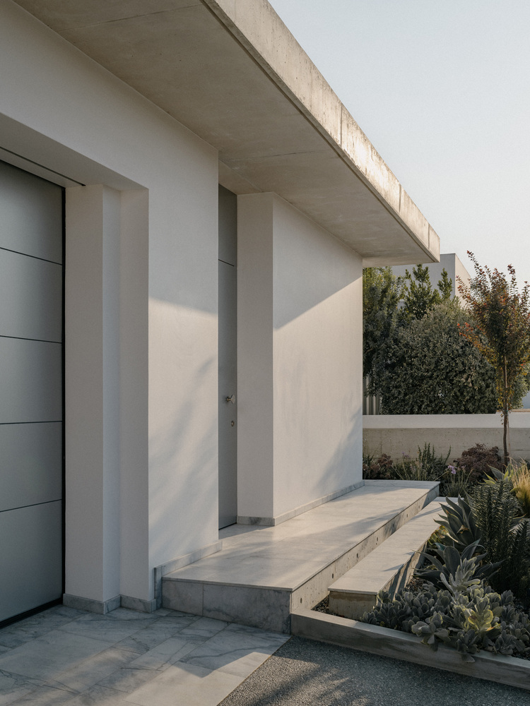 雕塑般裸露混凝土贯穿整个狭长矩形的平房设计