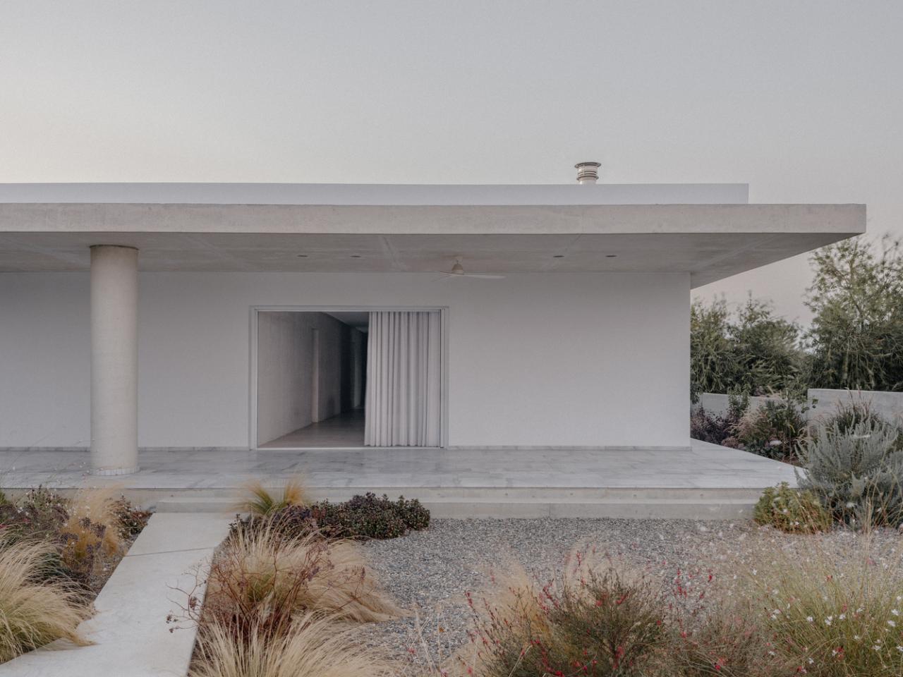 雕塑般裸露混凝土贯穿整个狭长矩形的平房设计