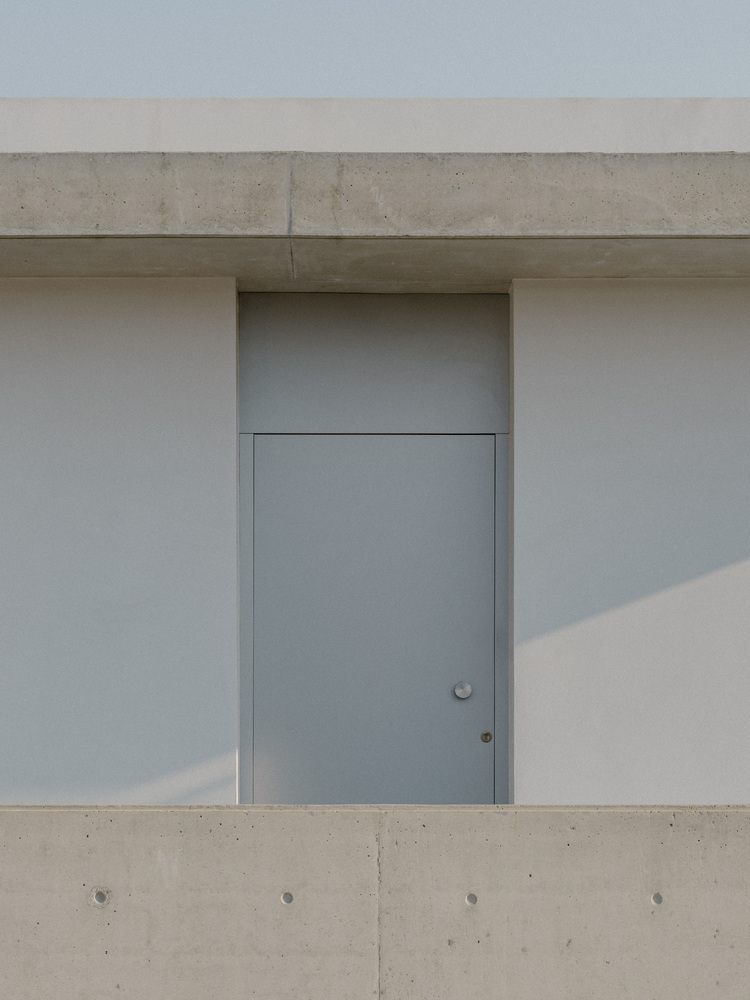 雕塑般裸露混凝土贯穿整个狭长矩形的平房设计