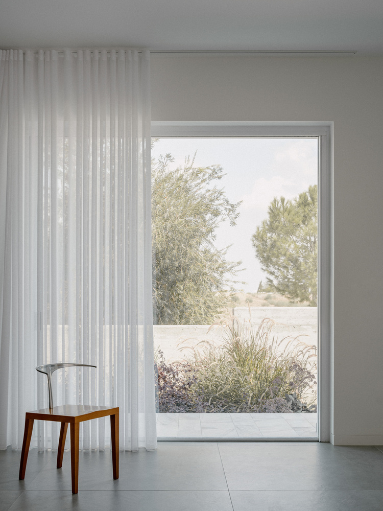 雕塑般裸露混凝土贯穿整个狭长矩形的平房设计