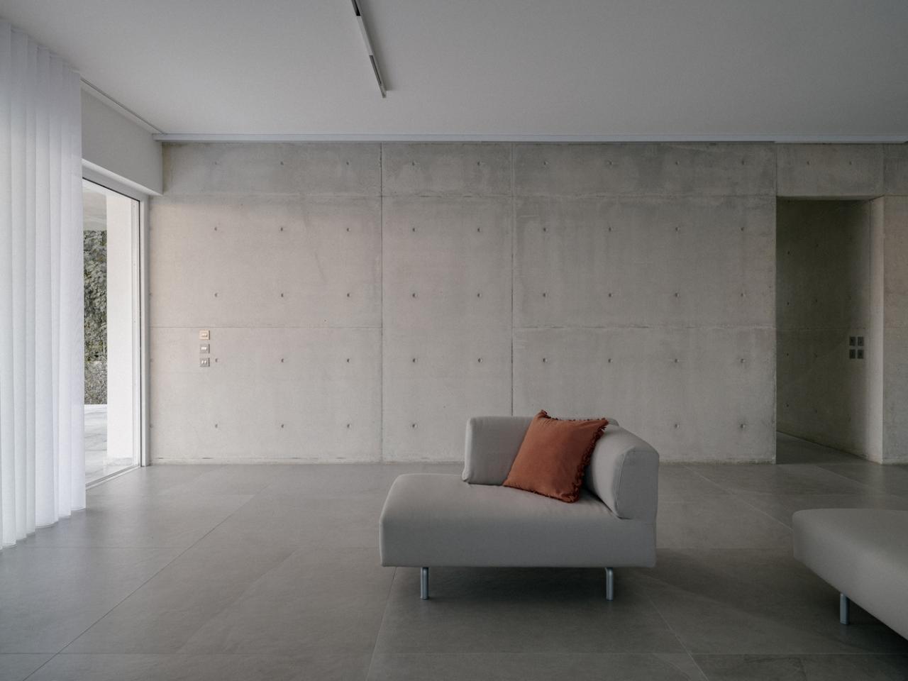 雕塑般裸露混凝土贯穿整个狭长矩形的平房设计