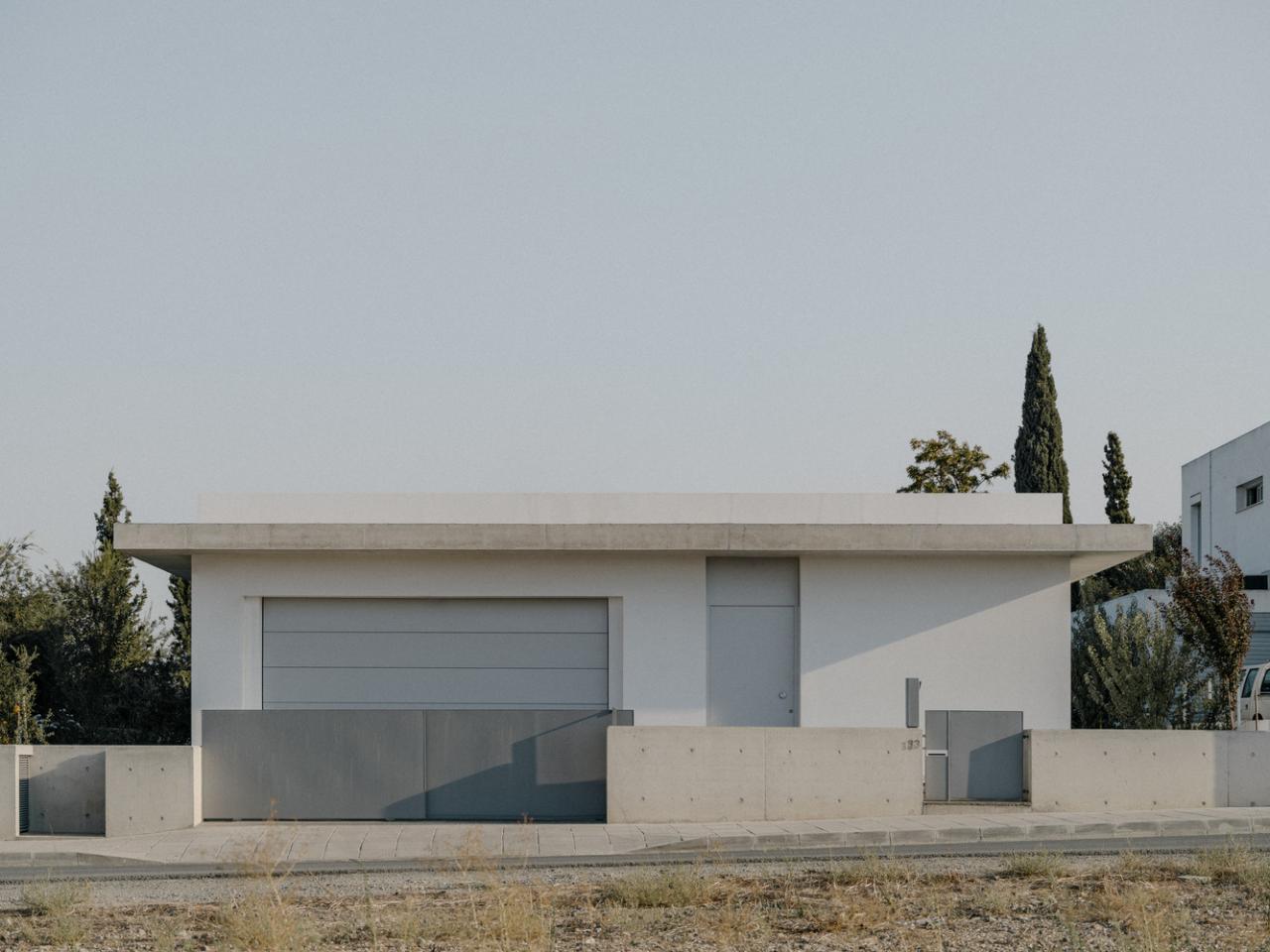 雕塑般裸露混凝土贯穿整个狭长矩形的平房设计